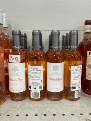 bottles of wine are lined up on a shelf in a store