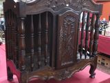 a wooden crib with a pink table cloth on it