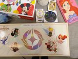 a box with a picture of disney characters on it next to a cup of coffee