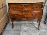 une petite commode dans le coin d'une pièce