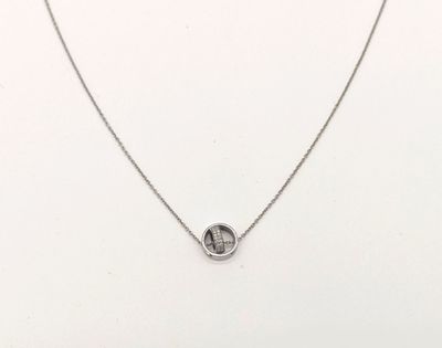 un collier blanc orné d'un cercle en argent, monté sur une chaîne en argent