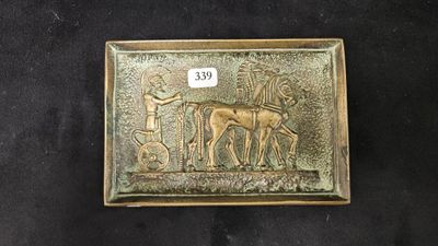 un gros plan d'une plaque métallique sur laquelle figurent un cheval et son cavalier