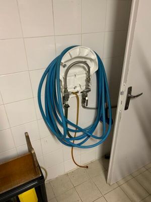 un tuyau bleu fixé au mur d'une salle de bains