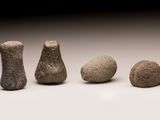 Plusieurs pierres de tailles différentes sont disposées en rangée sur une surface blanche.