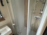 a bathroom with a shower, sink, and mirror in it