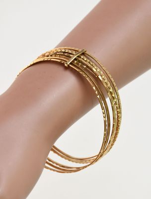 bracelets rigides plaqués or sur la main d'un mannequin