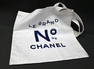 un sac fourre-tout blanc sur lequel est inscrit « Chanel »
