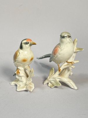 deux figurines d'oiseaux perchés sur une branche