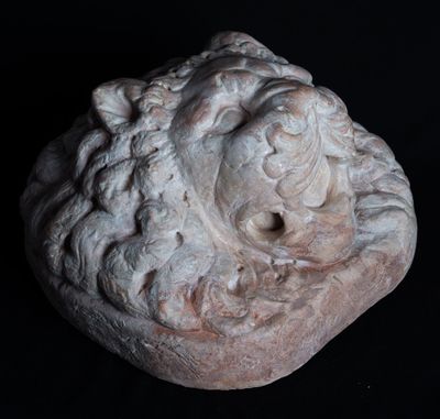 an image of a stone sculpture of a face on a black background
