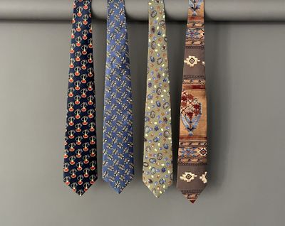 three different colored ties hanging on a clothes rack in a room