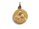 un gros plan d'une médaille d'or sur laquelle figure Jésus