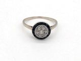 un gros plan d'une bague sertie de diamants sur une surface blanche