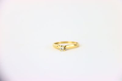 une bague en or surmontée d'un seul diamant