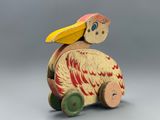 a wooden toy with a bird sitting on top of it