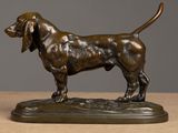 bronze statue of a dog standing on a base on a table