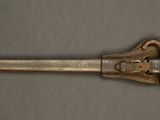 an old metal pipe cutter on a gray surface with a brown handle