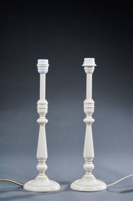pair of white candlesticks on a grey background