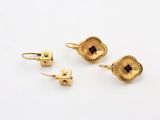 three pairs of gold earrings on a white surface