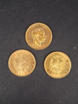 trois types différents de pièces d'or posées sur une surface noire
