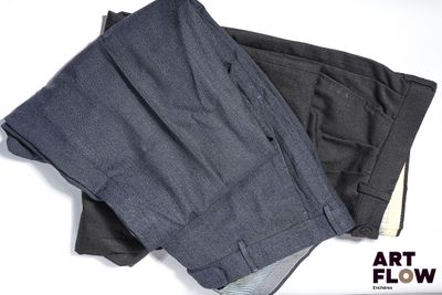 deux pantalons pour homme posés l'un à côté de l'autre sur une surface blanche