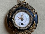 a blue and gold clock hanging on a white wall