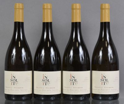 four bottles of wine are lined up on a table