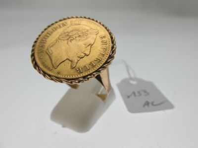 Gros plan sur une bague en or ornée d'une pièce de monnaie