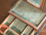 a small wooden box with a mirror on top of it