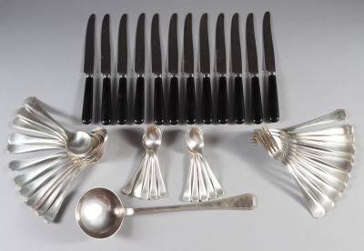 Plusieurs cuillères et couteaux-cuillères sont alignés sur une table