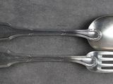 deux cuillères et une fourchette en argent sur une table