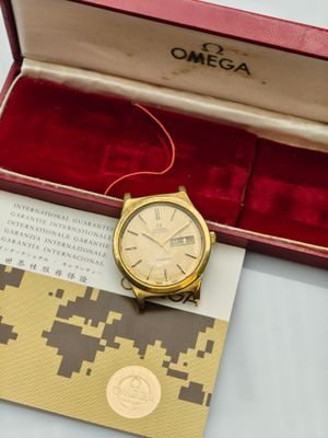 an image of a gold watch sitting in a red box on a table