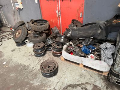a pile of old tires and wheels in a garage