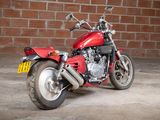 a red motorcycle that is parked in front of a brick wall