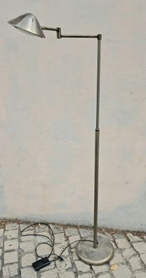 un lampadaire posé au sol près d'un mur