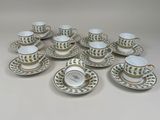 neuf tasses et soucoupes avec une horloge dessus