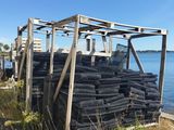 a pile of tires sitting on the beach next to the water