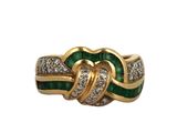 a close up of a gold ring with green and white stones