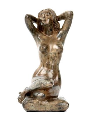 statue of a woman sitting on a rock with her hands behind her head