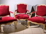 three red chairs with gold trim are sitting on a tiled floor