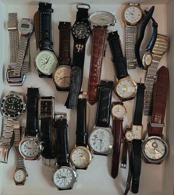 de nombreux modèles de montres exposés dans une vitrine blanche