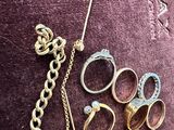a lot of rings and other jewelry on a purple surface