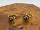 pair of gold rings with black diamonds on a wooden surface