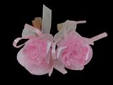 pair of pink roses with ribbon and bows on a black background