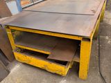 a yellow table with a drawer underneath it in a warehouse