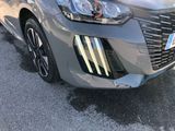 the front end of a silver car parked in a parking lot
