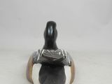 an image of a black and white figurine sitting on top of a wooden base