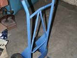 un diable bleu avec une poignée noire dans un garage