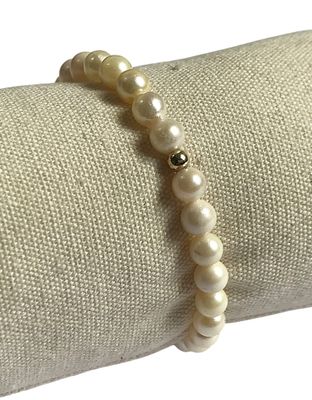 bracelet de perles posé sur une serviette, muni d'un fermoir à perle dorée