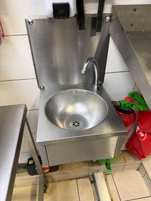 a sink in the middle of a kitchen with a red bag