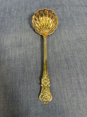 une cuillère en or ornée d'une fleur, posée sur une table